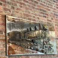 Metallisches Wandbild einer Lokomotive auf Backsteinwand im Restaurant.